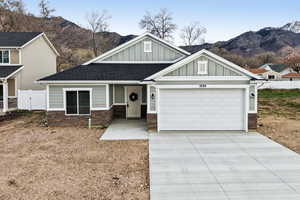 Craftsman-style home with board and batten siding, a garage, driveway, and a mountain view