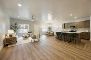 Living area with ceiling fan, a chandelier, and light wood-style floors
