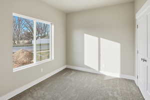 Unfurnished bedroom featuring carpet and baseboards