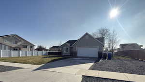View of front of home featuring concrete driveway, stucco siding, a residential view, and an attached garage
