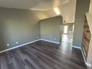 Additional living space with lofted ceiling, dark wood finished floors, and a ceiling fan