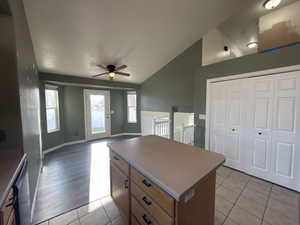 Kitchen with a center island, light tile patterned flooring, open floor plan, ceiling fan, and brown cabinets