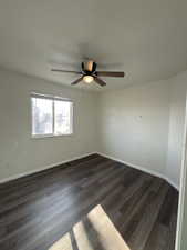 Unfurnished room featuring dark wood finished floors and a ceiling fan