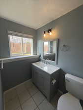 Half bath with vanity and light tile patterned floors