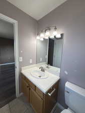 Half bath with vanity and light tile patterned floors