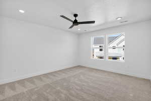 Carpeted spare room with ceiling fan, a textured ceiling, and recessed lighting
