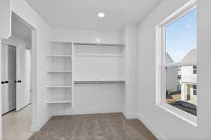 Walk in closet with light carpet