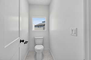 Bathroom with toilet and light marble finish floors