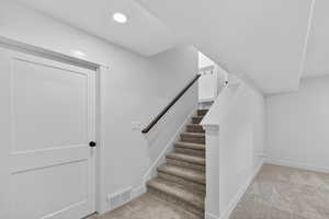 Stairway with carpet floors and baseboards