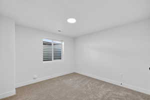 Empty room featuring baseboards and carpet flooring
