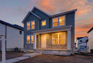 View of front of house featuring board and batten siding and stone siding