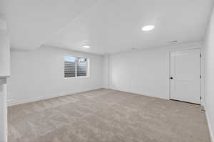 Spare room with light colored carpet and baseboards