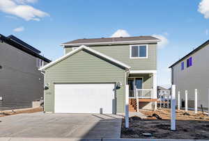 View of front of house featuring concrete driveway and a garage