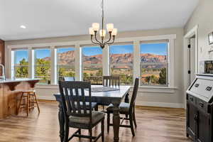 Dining room with a mountain view, light wood-style floors, and a chandelier
