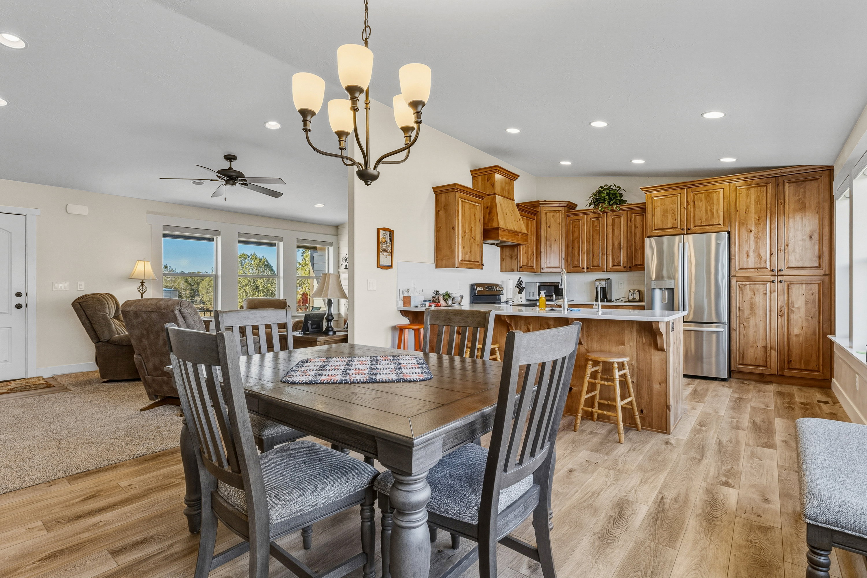 Dining room with a chandelier, ceiling fan, recessed lighting, and light wood-style floors