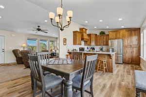Dining room with a chandelier, ceiling fan, recessed lighting, and light wood-style floors