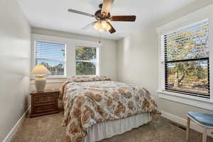 Carpeted bedroom featuring baseboards and ceiling fan