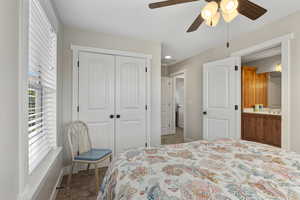 Bedroom with carpet floors, a closet, ceiling fan, and connected bathroom
