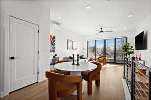Dining area with wood finished floors, ceiling fan, recessed lighting, and an AC wall unit