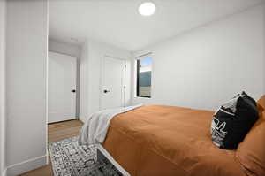 Bedroom with wood finished floors and baseboards