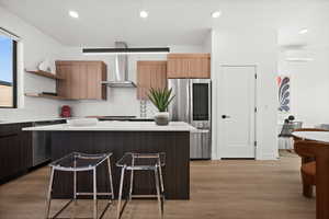 Kitchen with modern cabinets, stainless steel appliances, open shelves, light wood-style floors, and a center island