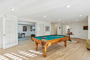 Game room featuring french doors, light wood finished floors, billiards table, and recessed lighting
