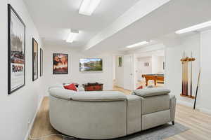 Living room with billiards and light wood finished floors