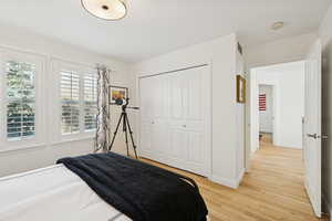 Bedroom featuring light wood-style floors and a closet