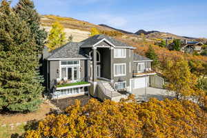View of front of property featuring stucco siding, a mountain view, concrete driveway, a garage, and a patio
