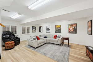 Living area with light wood finished floors and baseboards