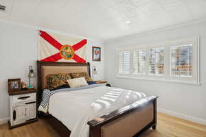 Bedroom with light wood-style flooring and ornamental molding