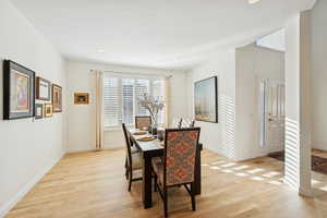 Dining space with light wood finished floors and recessed lighting