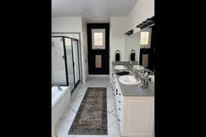 Full bath with a stall shower, double vanity, and a garden tub