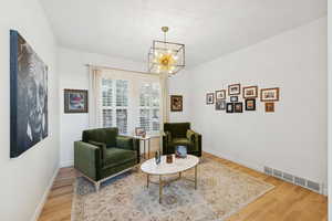 Sitting room with light wood-style flooring and a chandelier