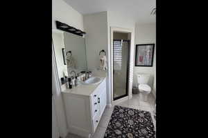 Bathroom with a shower stall, vanity, and light tile patterned floors