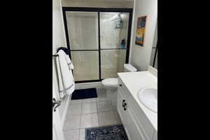 Bathroom featuring vanity, a stall shower, and light tile patterned flooring