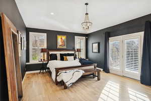Bedroom featuring light wood finished floors, access to outside, a chandelier, and recessed lighting