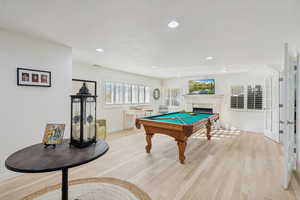 Recreation room with billiards, light wood finished floors, a fireplace, and recessed lighting