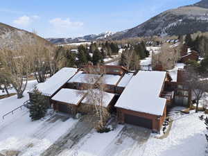 Snowy aerial view with a mountain view and a residential view