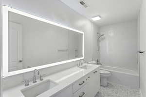 Bathroom featuring double vanity and shower / bath combination