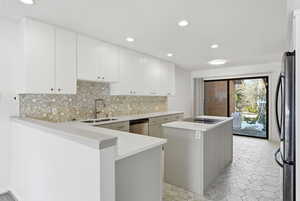 Kitchen featuring a center island, tasteful backsplash, stainless steel appliances, white cabinetry, and recessed lighting