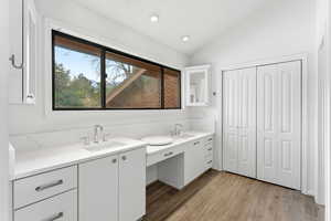 Full bathroom with vanity, light wood-type flooring, recessed lighting, lofted ceiling, and a closet