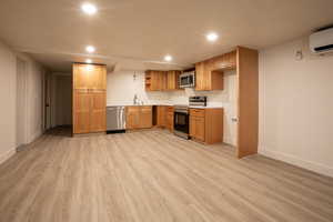 Kitchen with recessed lighting, stainless steel appliances, light countertops, light wood-style floors, and open shelves