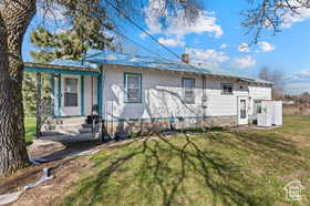 View of front of house with a front yard, a chimney, and a porch