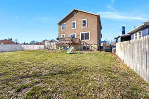 Rear view of property featuring a wooden deck, a fenced backyard, stucco siding, and a gazebo