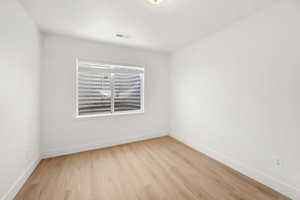 Spare room featuring light wood-style floors and baseboards