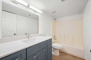 Full bathroom with vanity, washtub / shower combination, and light wood finished floors