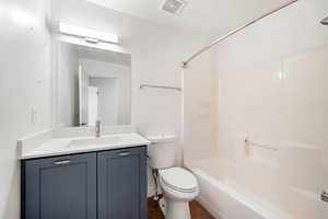 Full bath with vanity, shower / bath combination, and dark tile patterned flooring