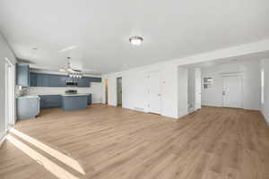Unfurnished living room with light wood-style flooring and stairway