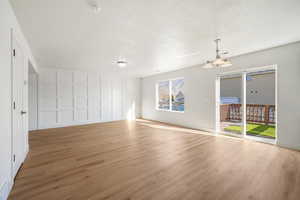 Spare room with light wood-type flooring, a chandelier, and a textured ceiling
